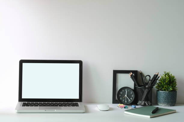 istock Laptop computer, picture frame, houseplant and stationery on white table. Modern workplace. 1403611598