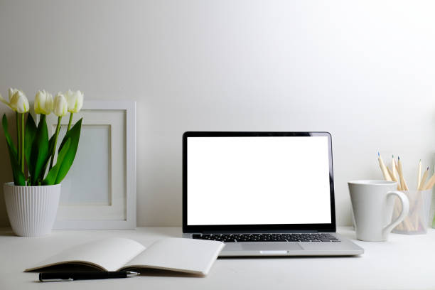 istock Comfortable workplace with computer laptop, coffee cup, notebook, picture frame and flower pot. 1403612258