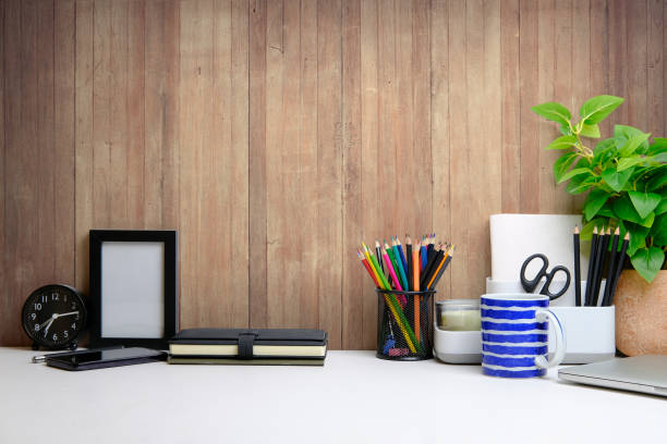 istock Stylish workplace with flower pot, coffee cup and stationery on white table. Home office. Copy space for advertise text, information content. 1403612559