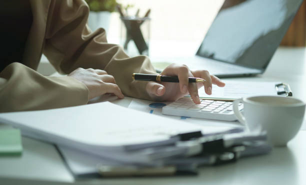 istock Cropped shot young female accountant using calculator and checking financial reports. 1403616868