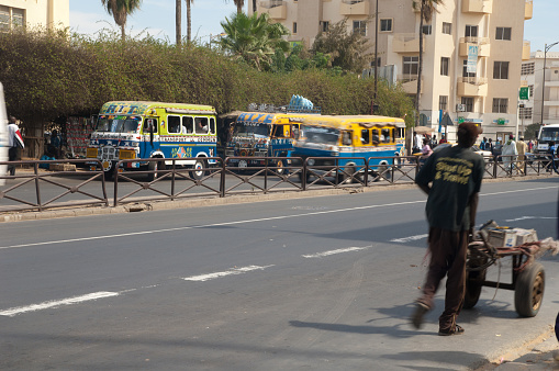 Road with buses and people in the city of Dakar. Senegal.