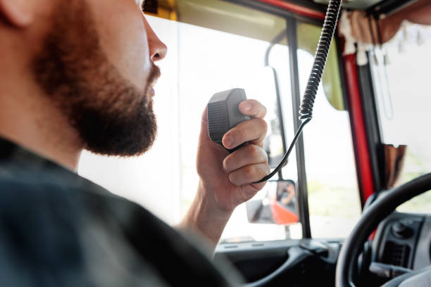 Truck driver talking by CB radio system in his vehicle Male truck driver talking by CB radio system in his vehicle semi truck audio stock pictures, royalty-free photos & images