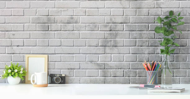 istock Creative workplace with photo frame, houseplant, coffee cup and pencil holder on white table. Copy space for advertising text. 1403617550