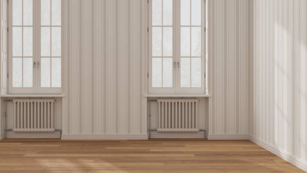 istock Empty room interior design in white and beige tones, open space with parquet wooden floor, windows with radiators, striped wallpaper, classic architecture concept idea 1403619800