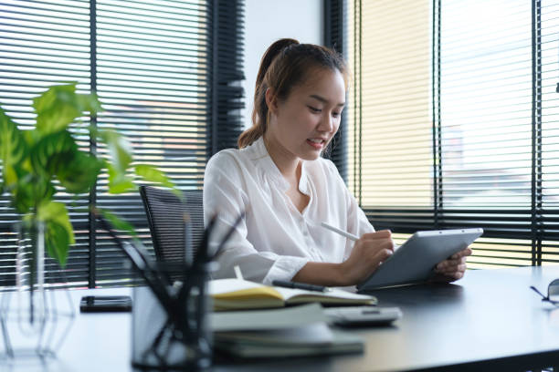 istock Happy businesswoman using stylus pen writing some information on digital tablet. 1403619946