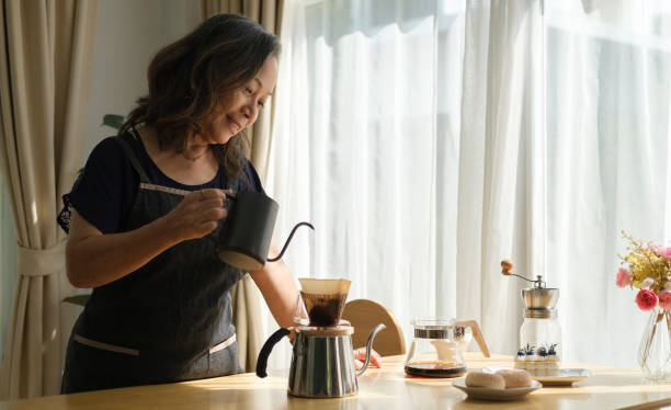 istock Happy middle aged woman preparing coffee for breakfast in comfortable home kitchen. Retirement, Healthy seniors lifestyle. 1403620102