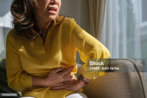 Unhappy Older Lady Putting Hands On Belly Having Painful Feeling In Abdomen Suffering From Strong Stomach Ache Gastritis Symptom Stock Photo - Download Image Now