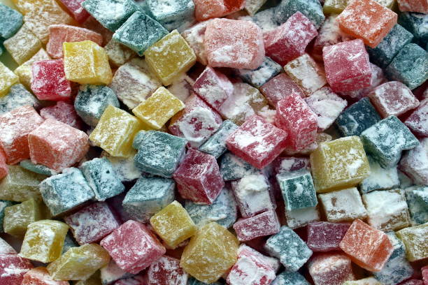 istock Background of multi-colored square marmalades sprinkled with powdered sugar. 1403620350