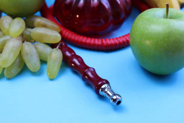 Details of a hookah with fruits lie on a blue background.