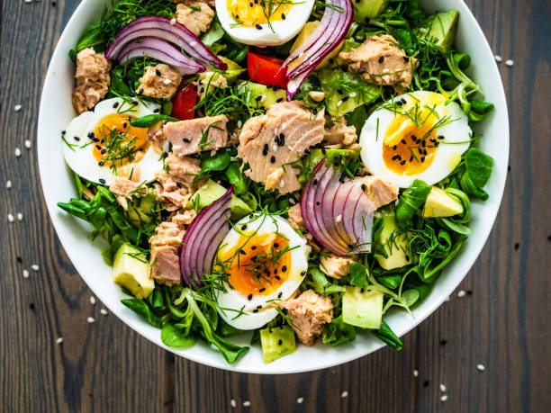 istock Tuna, boiled eggs, avocado and vegetable salad  on wooden background 1403621393