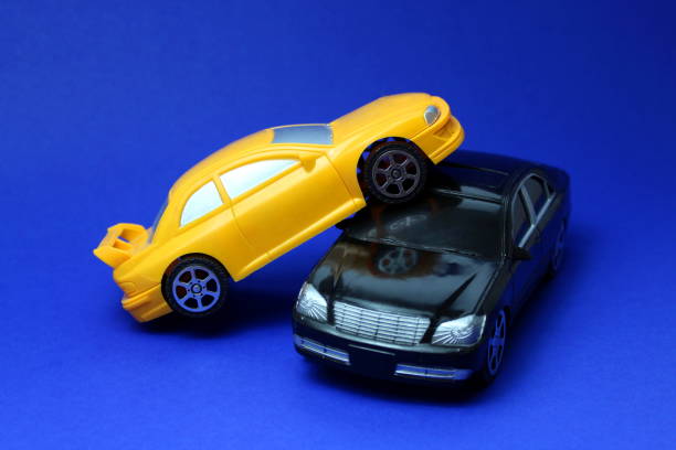 istock A yellow toy car drove into a black one simulating an accident. 1403621414