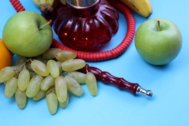 Hookah with fruits lie on a blue background.
