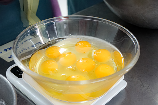 Raw egg white and egg yolk in a bowl