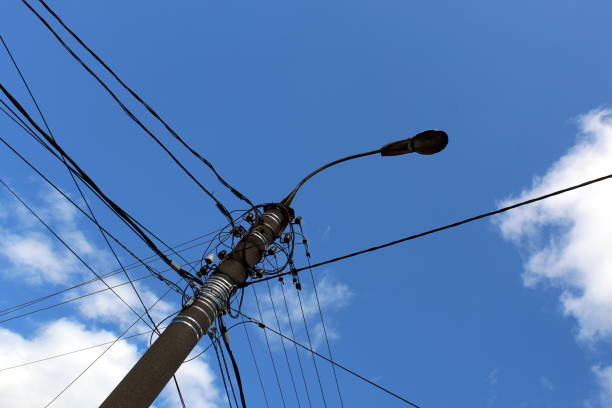 A tall pole with lots of cables and a lantern. A tall pole with lots of cables and a lantern. utility pole with power lines close up stock pictures, royalty-free photos & images