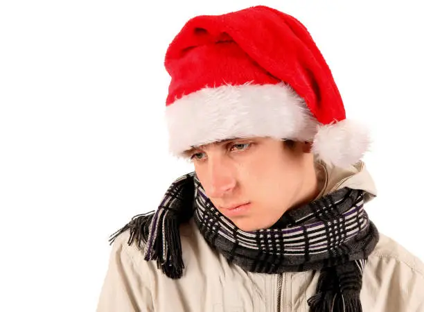 Sad Young Man Portrait in Santa Hat On The White Background closeup