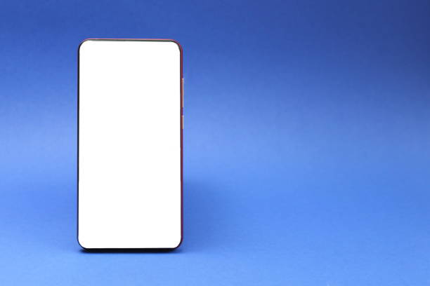 istock A cell phone with an isolated screen stands on a blue background. 1403627660