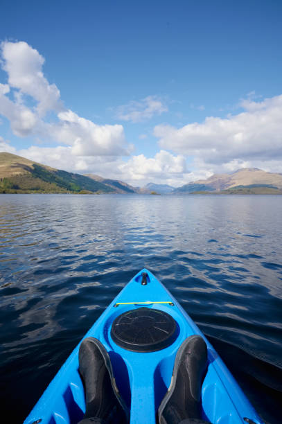 blue kayak on open water at loch lomond - loch rowboat lake landscape imagens e fotografias de stock