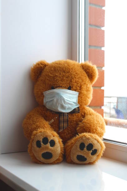 istock On the windowsill is a toy bear with a mask on its face. 1403631832