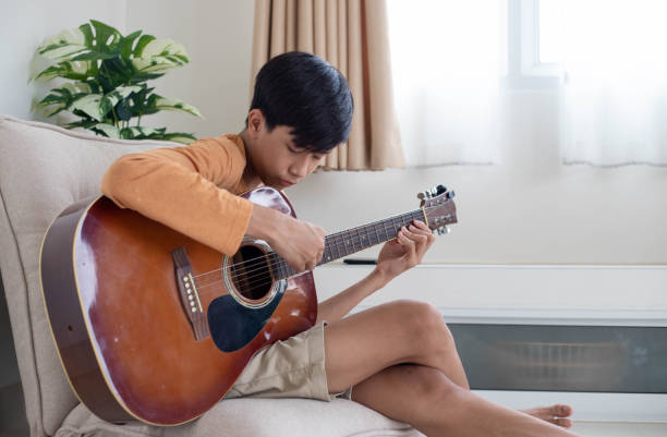 istock man playing guitar in living room 1403632041