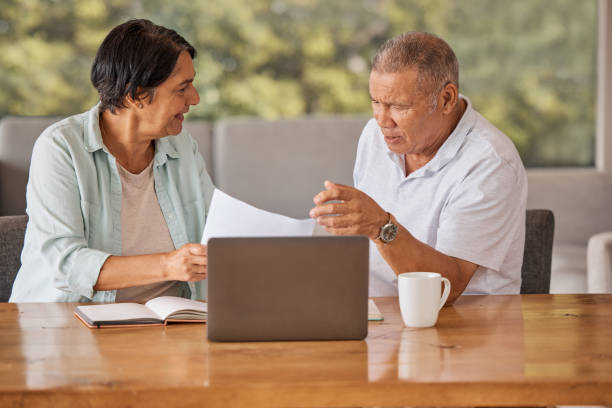 istock Elderly couple paying bills online on a laptop, sitting by a table at home getting angry, planning retirement. Senior hispanic man and woman having a dispute over finance and debt 1403633367