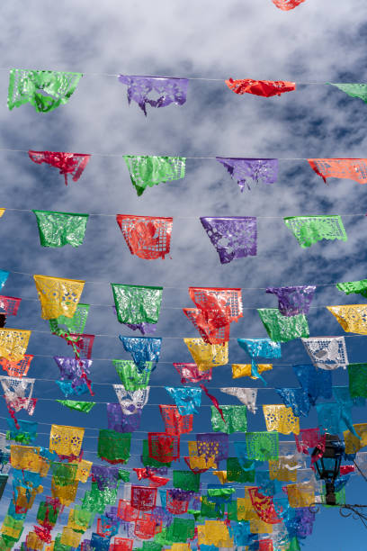 colorful mexican flags with a blue sky with clouds, celebration in mexico
