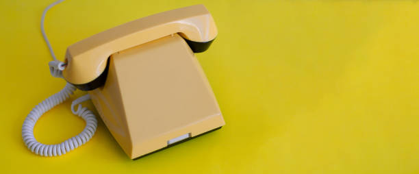 istock Yellow retro phone on a yellow background. Banner with space for text 1403635981