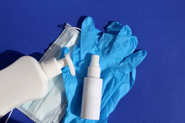 istock On a blue background are gloves, a mask, antiseptic bottles. 1403637598