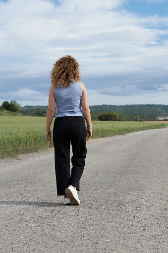 Woman walking on the road to the horizon outdoor