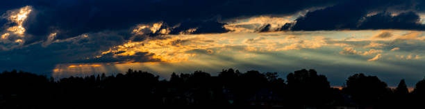 Large panorama of the sunlight passing through the clouds in a summer afternoon