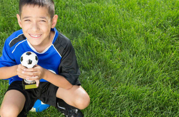 istock Little boy soccer player holding trophy 1403638409