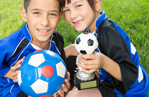 Team game. Dribbling activity. Portrait of boy, child, football player in uniform training isolated over white background. Concept of action, team sport game, energy, vitality. Copy space for ad.