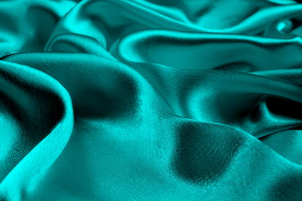 istock Background of turquoise draped satin fabric. 1403638653