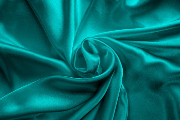 istock Background of turquoise draped satin fabric. 1403638782