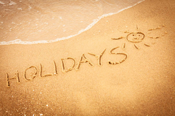 istock The word holidays written in the sand on a beach 1403639418
