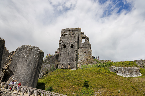 Dorset, UK- May 31, 2022: The scenic view of Corfe Castle. Corfe Castle is a fortification standing above the village of the same name on the Isle of Purbeck peninsula in the English county of Dorset, Built by William the Conqueror.