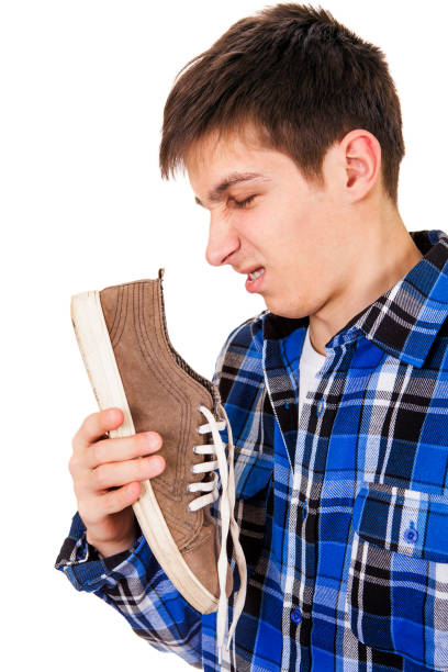 young man with a sneaker - facial expression unpleasant smell shirt caucasian imagens e fotografias de stock