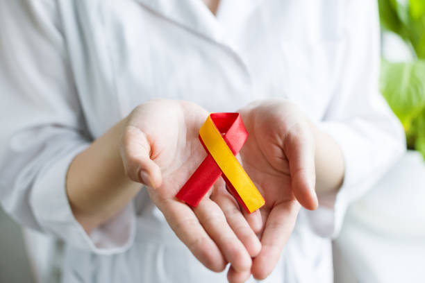 día mundial de la hepatitis. doctora mujer sosteniendo en sus manos cinta amarilla roja. sensibilización sobre la prevención y el tratamiento de la hepatitis viral. cáncer de hígado. día mundial contra el cáncer. estandarte. primer plano - hepatitis virus fotografías e imágenes de stock