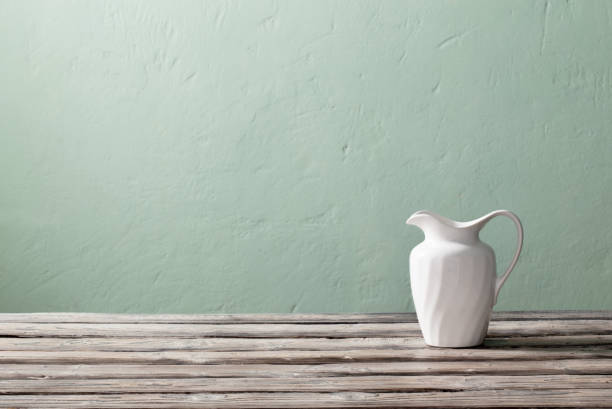 istock white jug on old wooden table on background green wall 1403642867