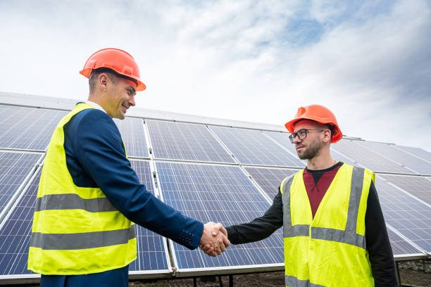 istock two young handsome men in overalls and caste shake hands after installing power panels. 1403644215