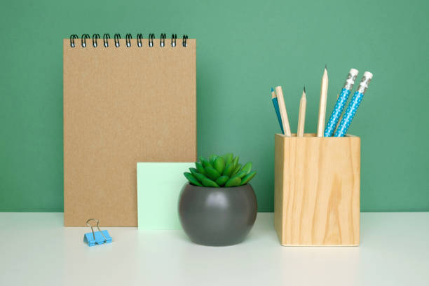 istock School equipment on white table, green wall background. Education backdrop. Wooden school supplies, notepad, pencils and cactus plant. Back to school. Student Desk . Stationery for study. Work at home 1403645471