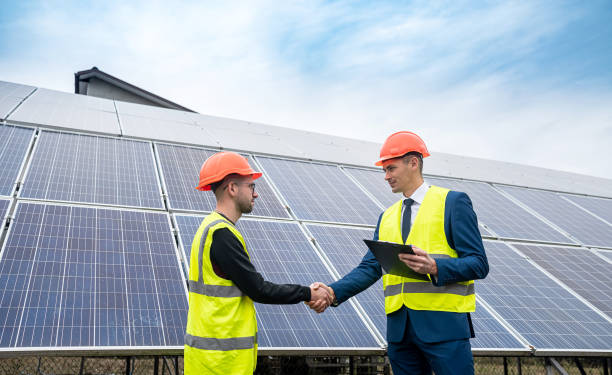 istock two young handsome men in overalls and caste shake hands after installing power panels. 1403645978