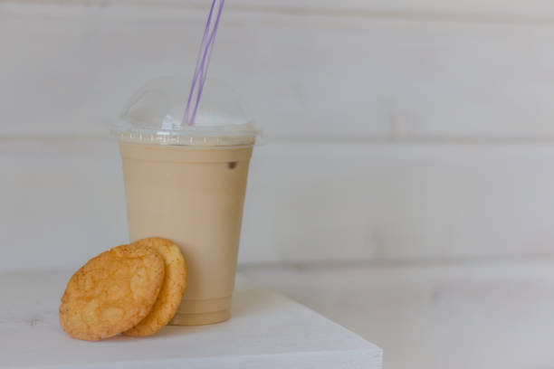 Iced coffee latte with cookies. Coffee to go with fresh bakery. Cold latte with drinking straw and cookies. Cold coffee with cakes. Breakfast dessert. Summer drinks. Cappuccino with homemade biscuit.
