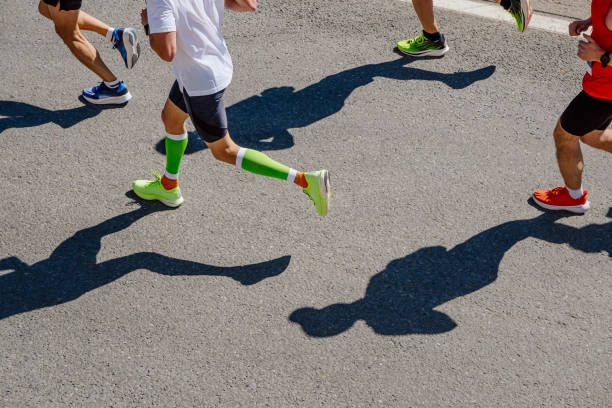 グループランナーアスリートがマラソンレースを走る トップビュー - marathon running group of people jogging ストックフォトと画像