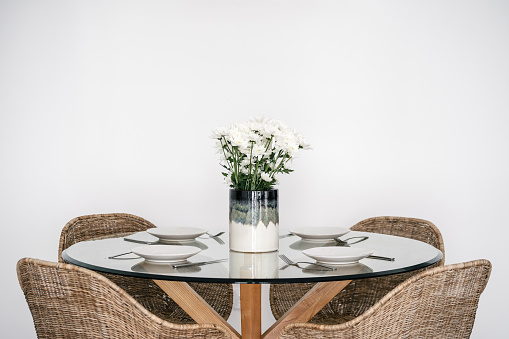 Contemporary interior design of bright and spacious dining room with decor and plates in Scandinavian style. Home comfort. Modern house for sale