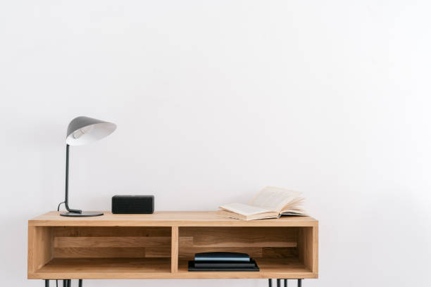 istock Open book and lamp on table near white wall 1403658842
