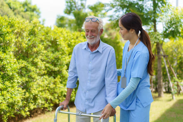 Young Asian woman nurse care giver helping senior old man with mobility walker in garden at home. Senior daycare center, Nurse take care elderly patient with cheerful concentrate Young Asian woman nurse care giver helping senior old man with mobility walker in garden at home. Senior daycare center, Nurse take care elderly patient with cheerful concentrate walking aide stock pictures, royalty-free photos & images