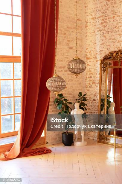 Modern Living Room In French Style Stylish French Interior With Big Window And Curtains Green Plant In Pot David Sculpture Vintage Gold Mirror And Crystal Chandeliers Against A Brick Wall Stock Photo - Download Image Now