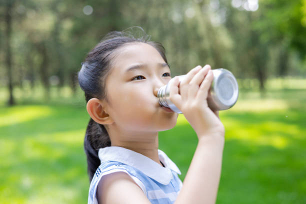 istock Little girl sitting and drinking on the roadside 1403664537