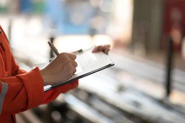 Photo of Writing on safety checklist document during safety audit and inspection.