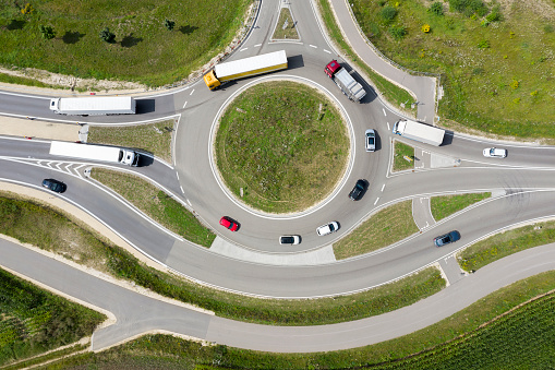 Cars and truck driving on a traffic circle, aerial view, directly above view.